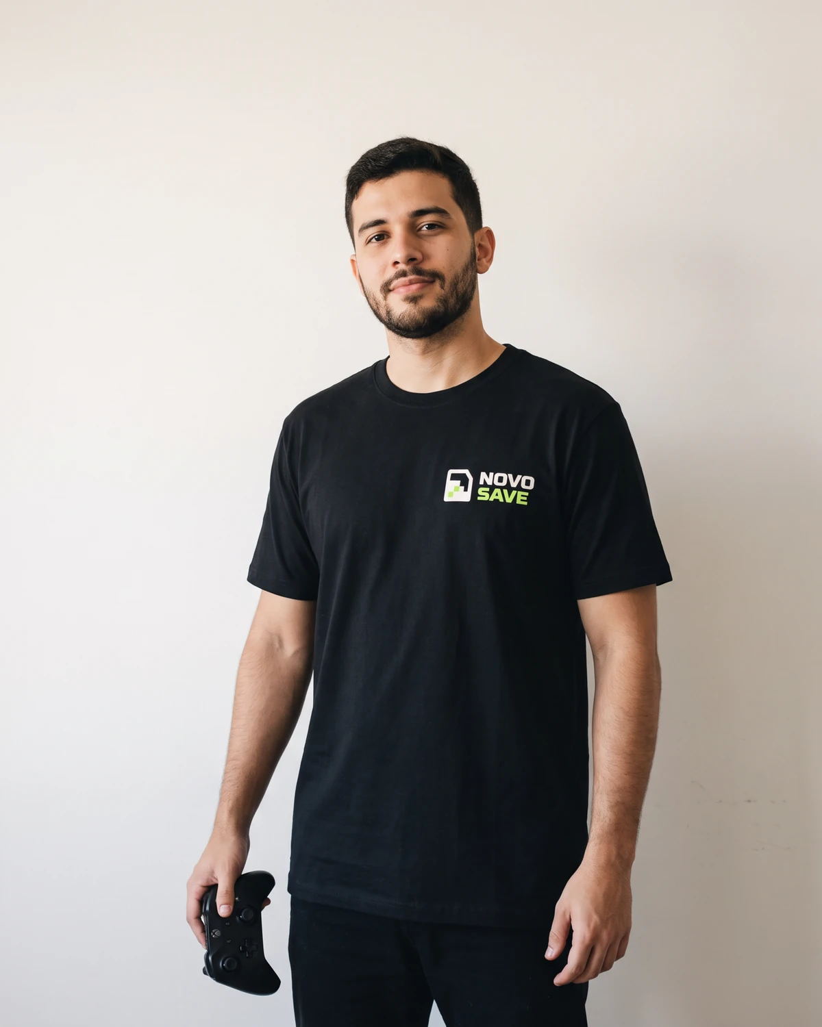 Rapaz com camiseta preta do Novo Save segurando um controle