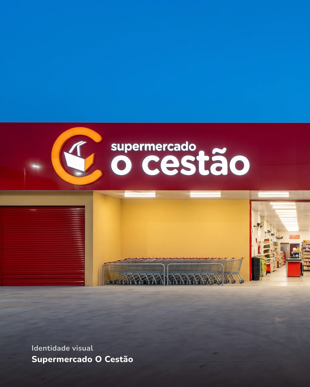 Fachada do Supermercado O Cestão ao anoitecer, com o letreiro vermelho iluminado